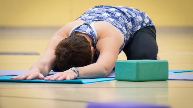 person in yoga pose on gym floor
