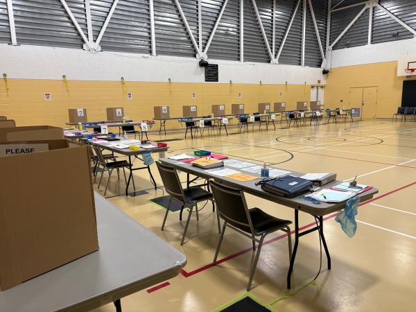 A picture of the voting location at Esquimalt Recreation Centre, featuring registration tables and voting booths